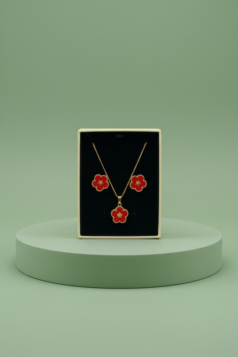 Hand holding a black jewelry box with red floral earrings and necklace.